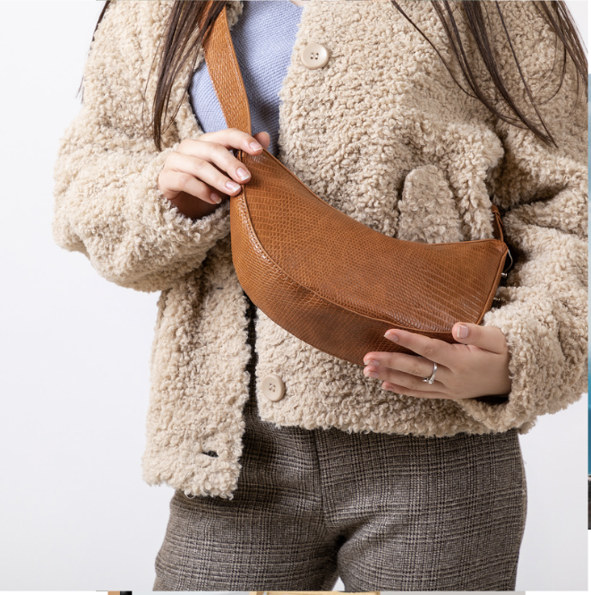 woman standing, showing her brown crossbody purse